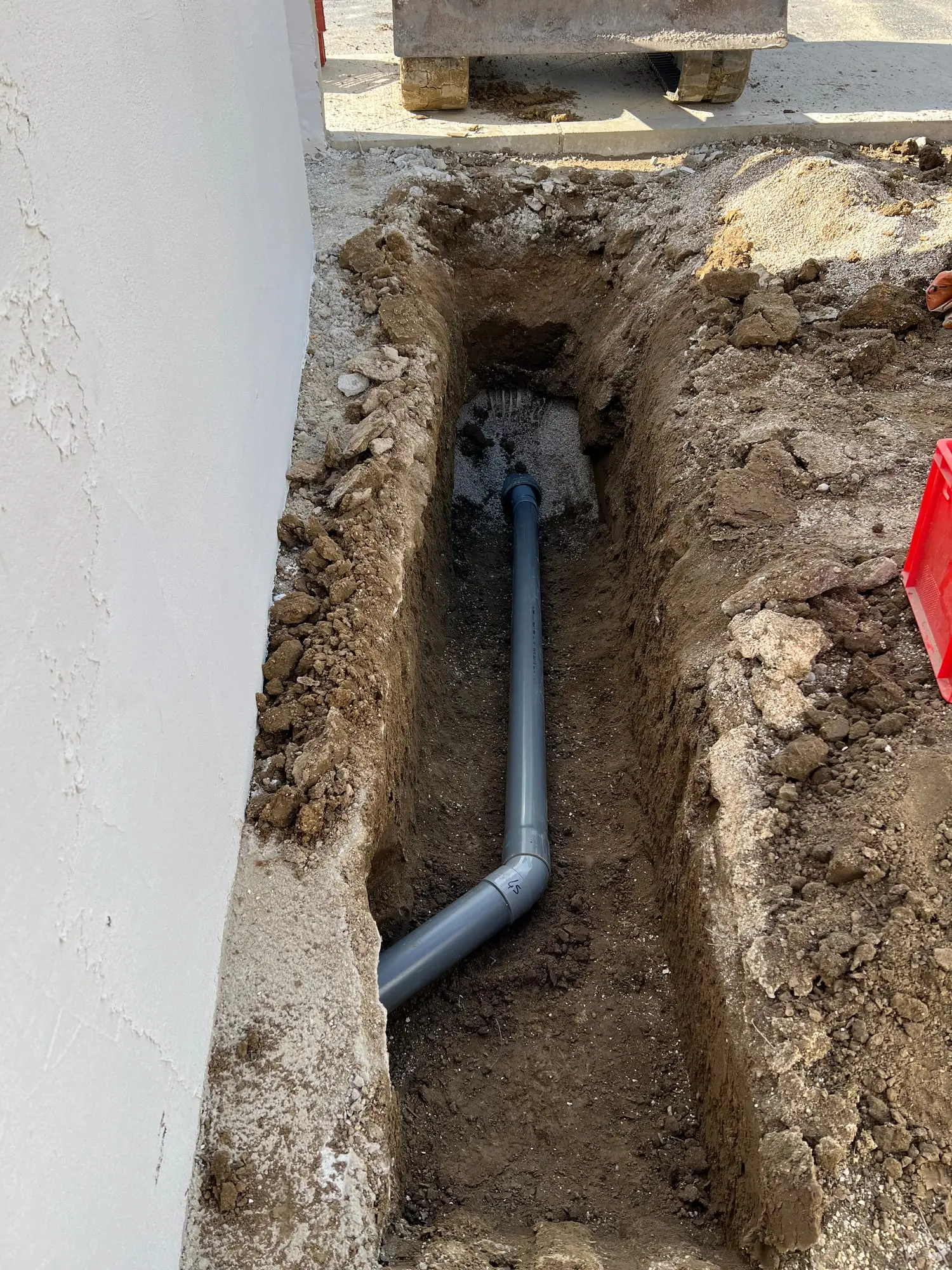Canalisation d’évacuation en PVC posée à la pente en fond de fouille