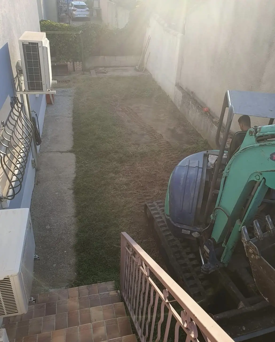 Bande de jardin étroite entre la maison et le mur mitoyen, avant travaux, à l'arrivée de la minipelle